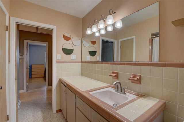 bathroom featuring vanity and tile walls