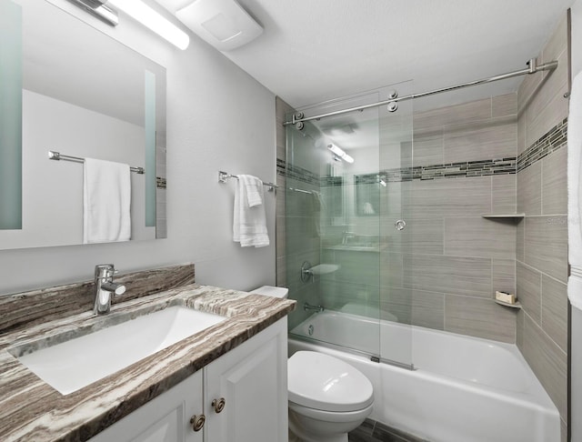 full bathroom with combined bath / shower with glass door, vanity, and toilet