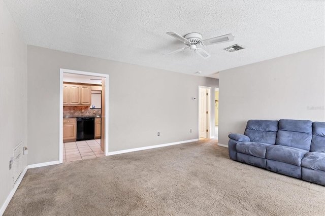 unfurnished living room featuring ceiling fan, light colored carpet, and a textured ceiling