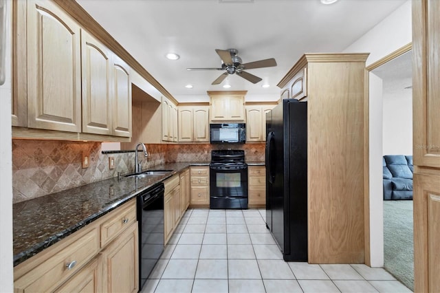 kitchen with black appliances, dark stone counters, sink, and light brown cabinets