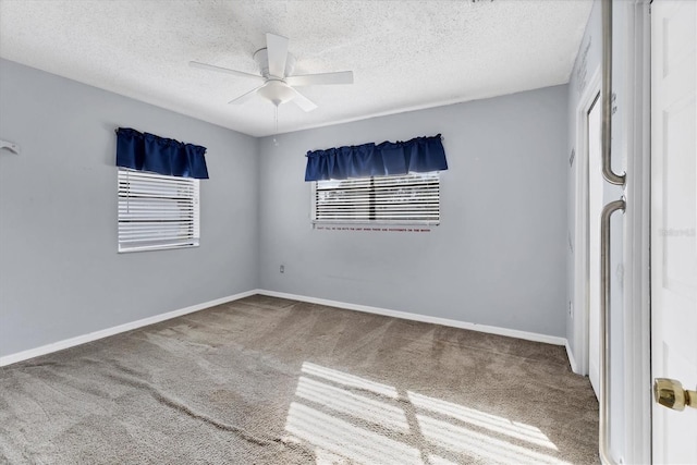 empty room with ceiling fan, carpet, and a textured ceiling