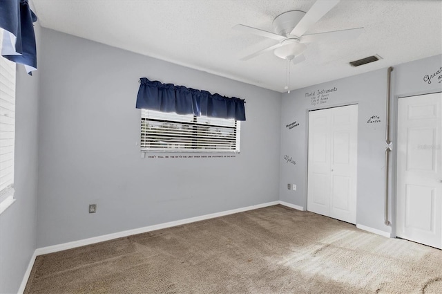 unfurnished bedroom featuring ceiling fan, carpet, and multiple windows