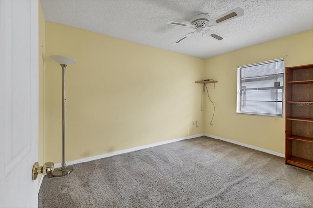 unfurnished room featuring a textured ceiling, ceiling fan, and carpet floors