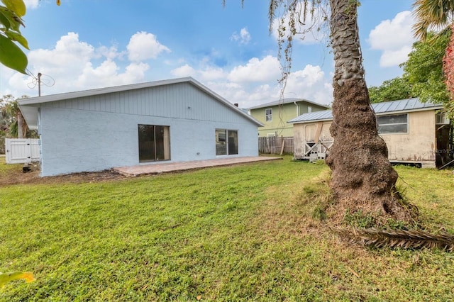 rear view of property featuring a lawn