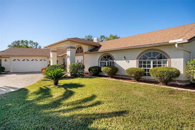 view of front of property with a front lawn and a garage