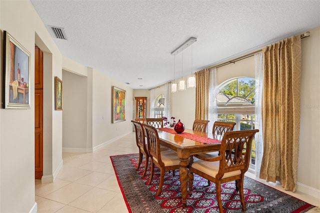 tiled dining area featuring a textured ceiling