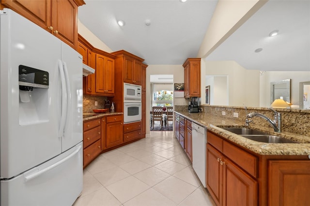 kitchen with white appliances, light stone counters, decorative backsplash, light tile patterned flooring, and sink