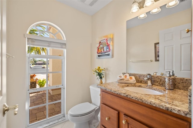 bathroom featuring a notable chandelier, tile patterned flooring, vanity, and toilet