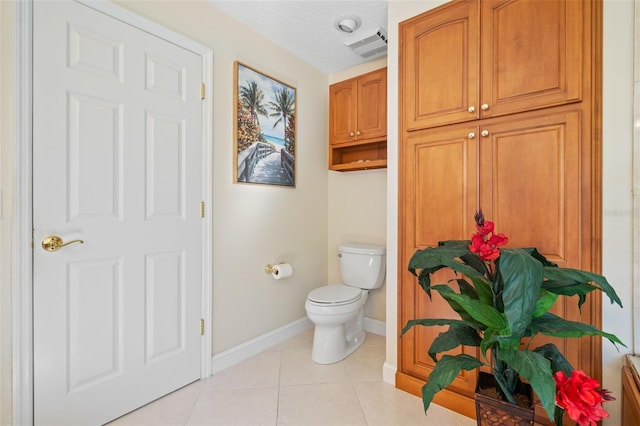 bathroom featuring a textured ceiling, tile patterned flooring, and toilet