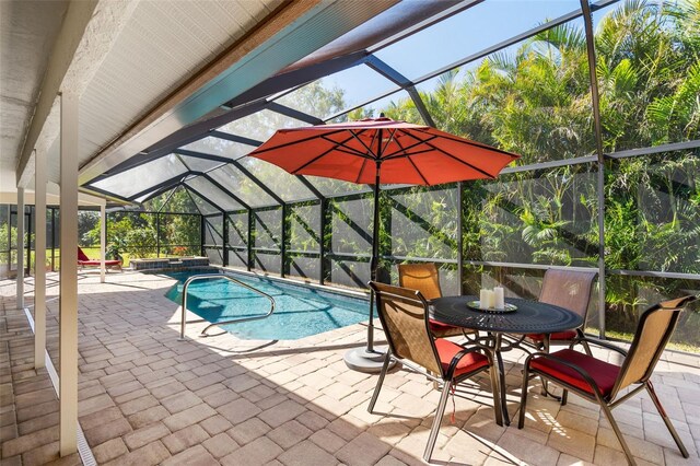 view of swimming pool featuring a patio area, a hot tub, and glass enclosure