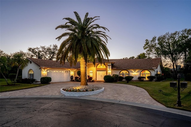 view of front of home featuring a lawn and a garage