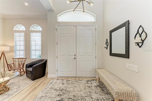 entryway with light wood-type flooring and ornamental molding