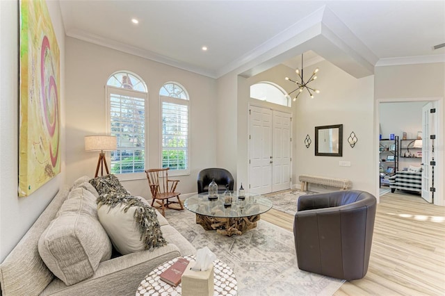 living room featuring hardwood / wood-style flooring, a chandelier, and ornamental molding