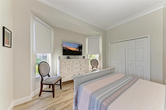 bedroom with a closet, light hardwood / wood-style floors, and ornamental molding