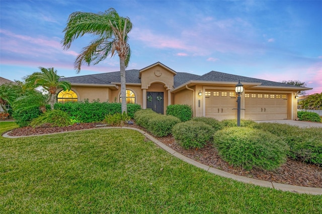 view of front of property featuring a lawn and a garage