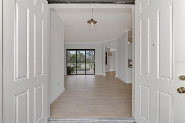 hall featuring light wood-type flooring and crown molding