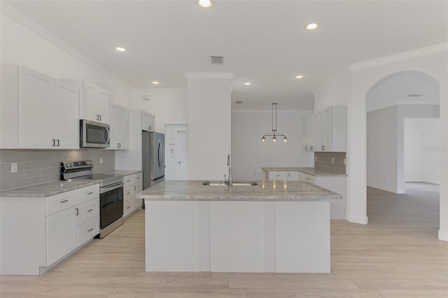 kitchen featuring stainless steel appliances, decorative light fixtures, sink, and white cabinets