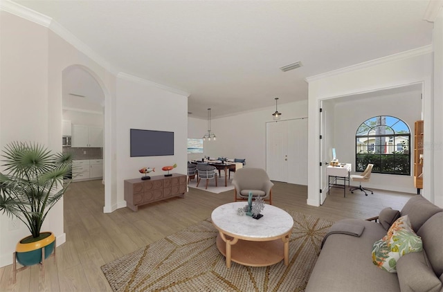 living room with crown molding and light wood-type flooring