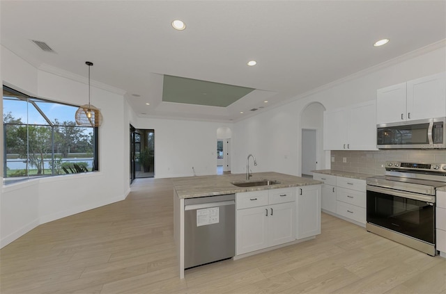 kitchen featuring pendant lighting, sink, white cabinetry, stainless steel appliances, and a center island with sink