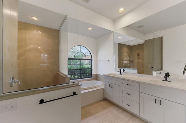 bathroom featuring hardwood / wood-style flooring, vanity, and separate shower and tub