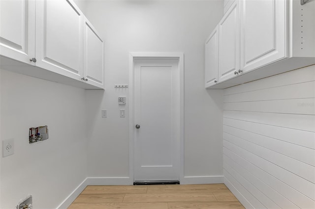 laundry room featuring hookup for a washing machine, light hardwood / wood-style floors, cabinets, and hookup for an electric dryer