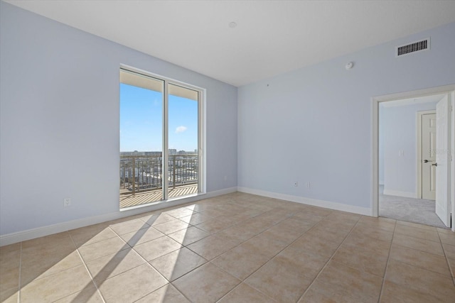 spare room featuring light tile patterned floors and plenty of natural light