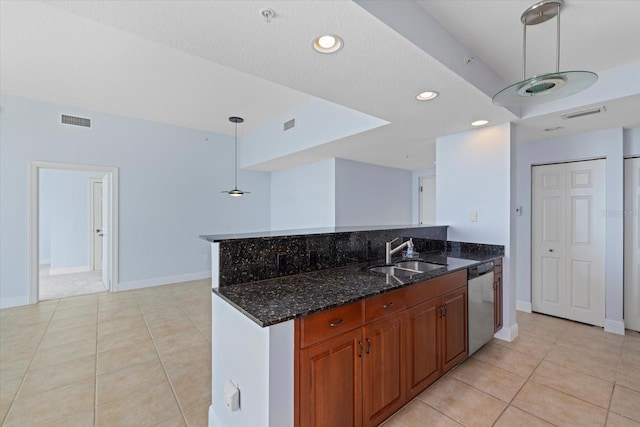 kitchen featuring dishwasher, decorative light fixtures, dark stone countertops, sink, and light tile patterned floors