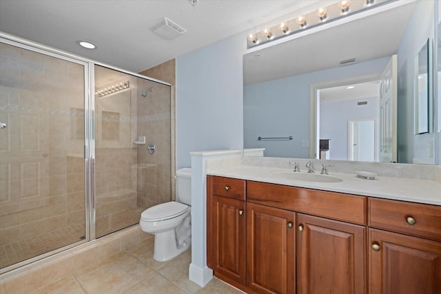 bathroom with toilet, vanity, tile patterned floors, and a shower with shower door