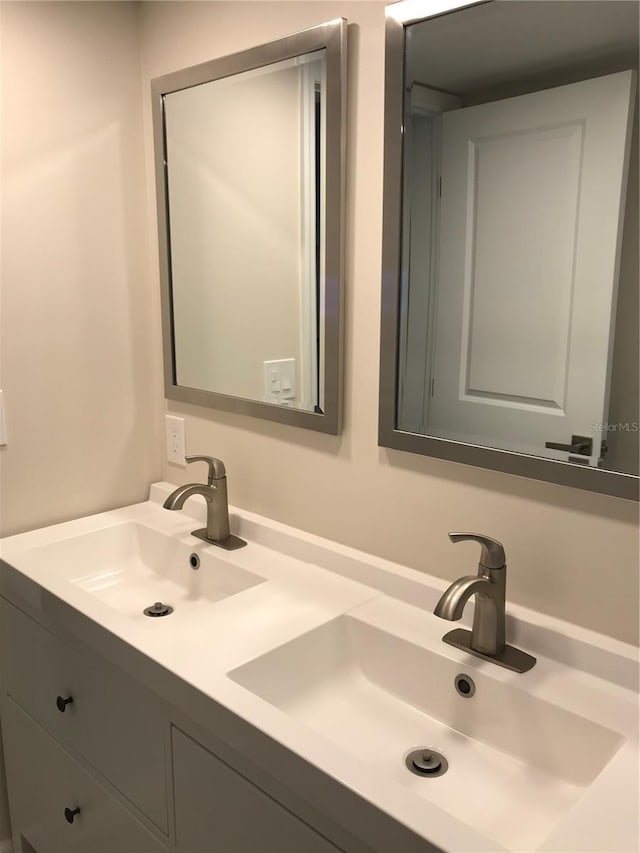 bathroom featuring a sink and double vanity