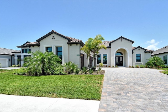 10612 Nicklaus Ct, Englewood, FL 34223 - mediterranean / spanish-style house with decorative driveway, stucco siding, a front lawn, a garage, and a tile roof