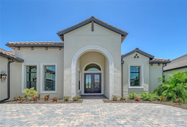 10612 Nicklaus Ct, Englewood, FL 34223 - doorway to property with french doors, stucco siding, and a tiled roof