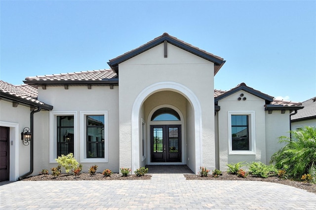 10612 Nicklaus Ct, Englewood, FL 34223 - property entrance featuring french doors, stucco siding, and a tiled roof