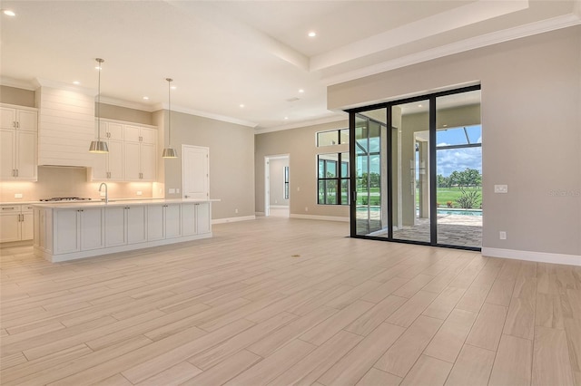 10612 Nicklaus Ct, Englewood, FL 34223 - unfurnished living room with baseboards, recessed lighting, light wood finished floors, crown molding, and a sink