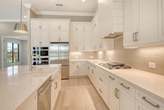 10612 Nicklaus Ct, Englewood, FL 34223 - kitchen with stainless steel appliances, crown molding, white cabinets, decorative light fixtures, and tasteful backsplash