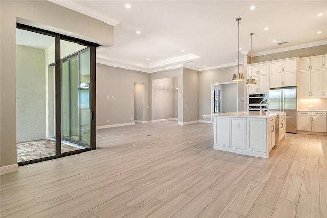 10612 Nicklaus Ct, Englewood, FL 34223 - kitchen featuring stainless steel appliances, light wood finished floors, light countertops, an island with sink, and ornamental molding