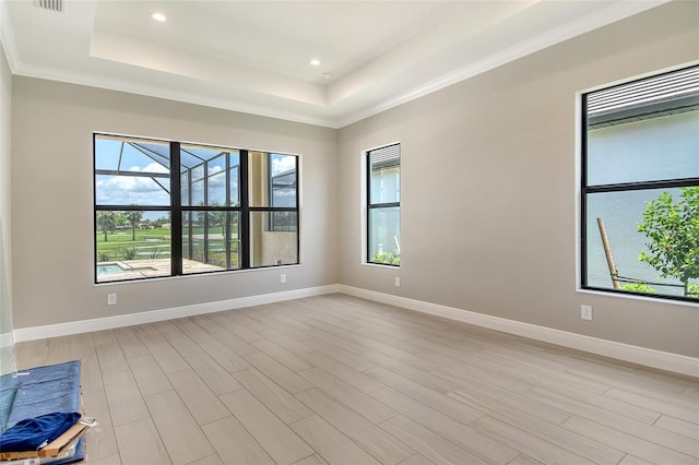 10612 Nicklaus Ct, Englewood, FL 34223 - empty room featuring a tray ceiling, baseboards, recessed lighting, light wood-type flooring, and ornamental molding