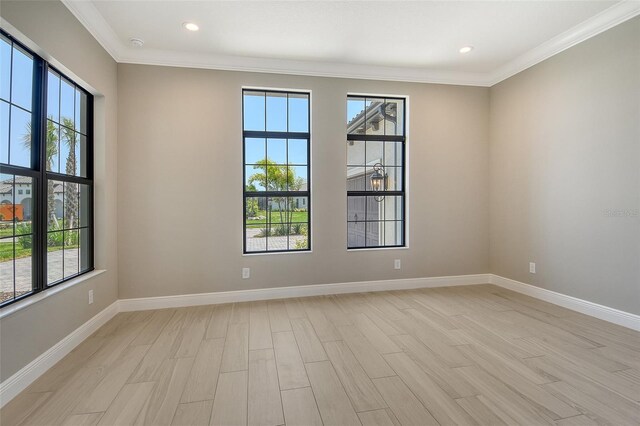 10612 Nicklaus Ct, Englewood, FL 34223 - spare room with ornamental molding, plenty of natural light, baseboards, light wood-type flooring, and recessed lighting