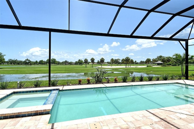 10612 Nicklaus Ct, Englewood, FL 34223 - view of pool with glass enclosure, a water view, a pool with connected hot tub, and a yard