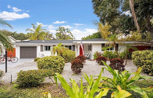 ranch-style home featuring a garage, driveway, and stucco siding