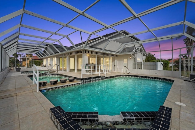 pool at dusk featuring glass enclosure and a patio area