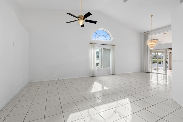 empty room featuring ceiling fan with notable chandelier, light tile patterned floors, and high vaulted ceiling