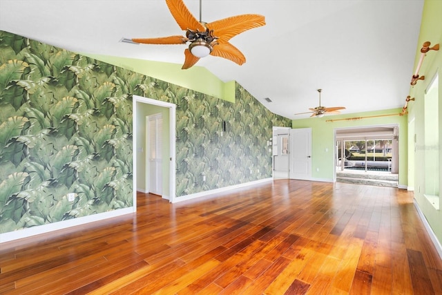 unfurnished living room with hardwood / wood-style floors and vaulted ceiling