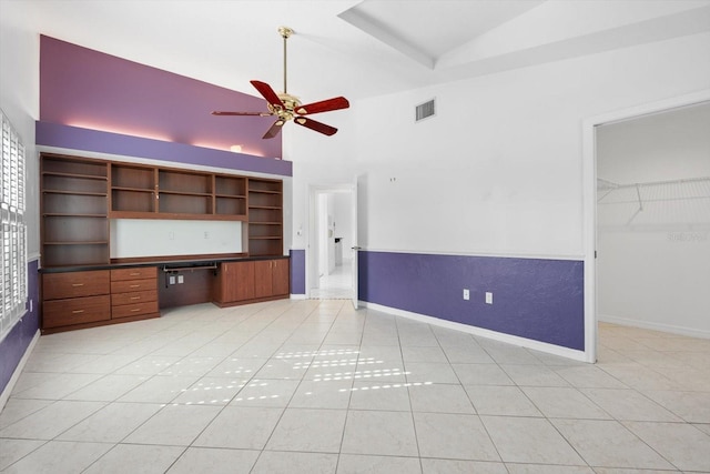 interior space featuring high vaulted ceiling, a walk in closet, ceiling fan, light tile patterned floors, and a closet