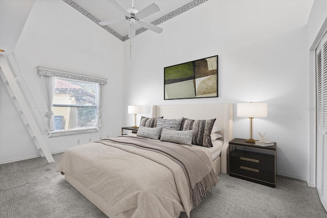 bedroom featuring ceiling fan, light colored carpet, a towering ceiling, and a closet