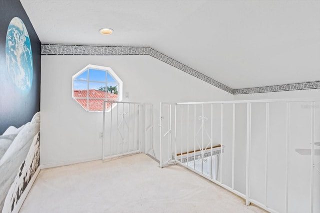 additional living space featuring carpet flooring and vaulted ceiling