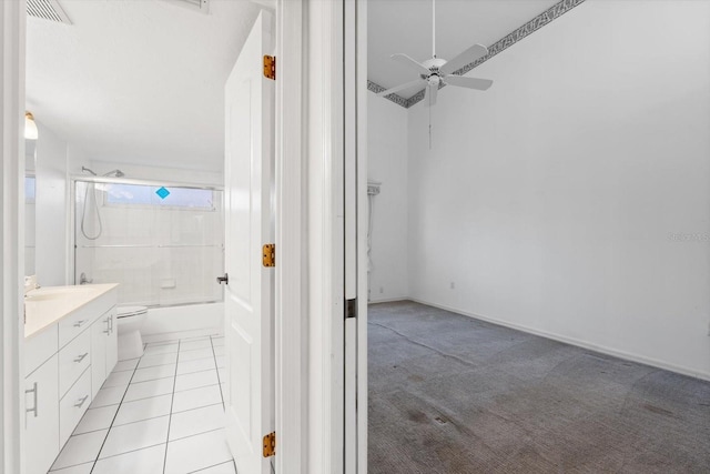 full bathroom featuring ceiling fan, tile patterned flooring, toilet, vanity, and shower / bathtub combination