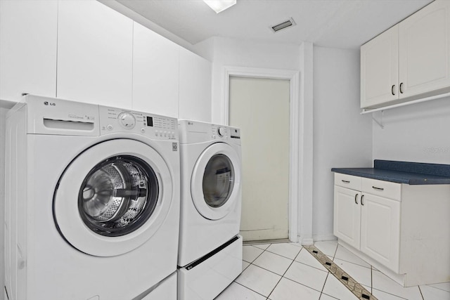 washroom with cabinets, independent washer and dryer, and light tile patterned flooring