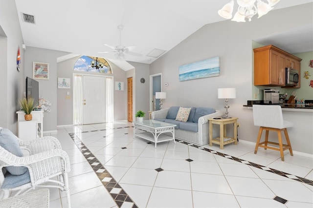 living room featuring lofted ceiling, light tile patterned floors, and ceiling fan with notable chandelier