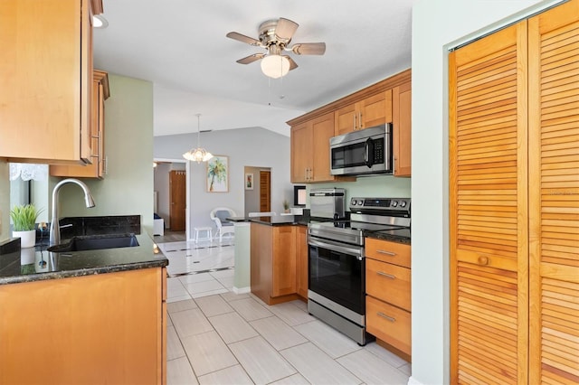 kitchen with sink, hanging light fixtures, vaulted ceiling, ceiling fan, and stainless steel appliances