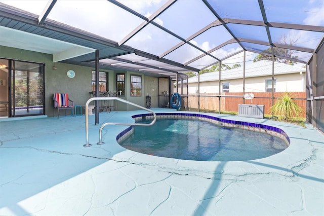 view of swimming pool featuring glass enclosure and a patio